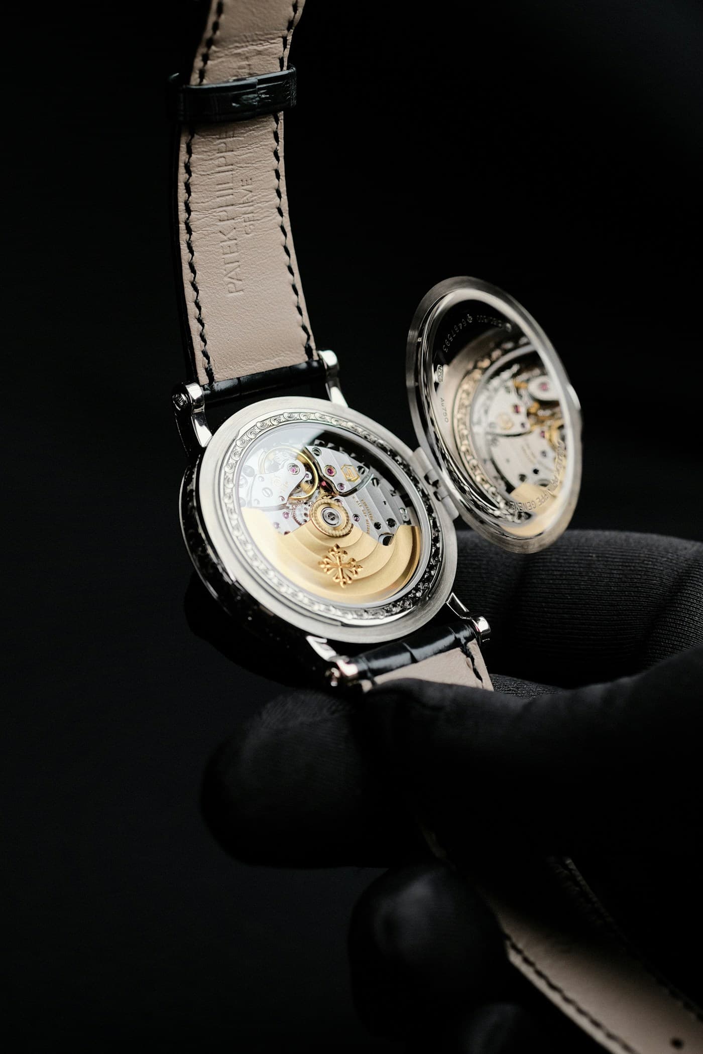 Patek Philippe Calatrava with diamond-set bezel, hinged officer caseback open showing the movement